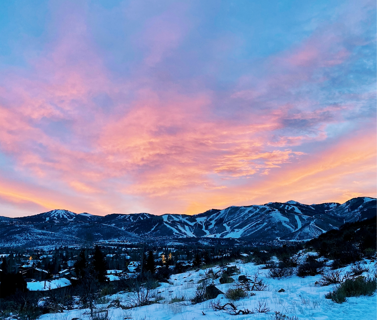 Image of a colorful sunset in park city utah. It is the best time for apres ski in Utah. Main Street has a ton of lively bars with live music and incredible apres ski scene. The night life in park city brings a ton of young people to the ski resort.